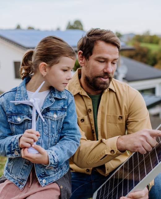 Father showing his little daughter solar photovoltaics panels, explaining how it working. Alternative energy, saving resources and sustainable lifestyle concept.